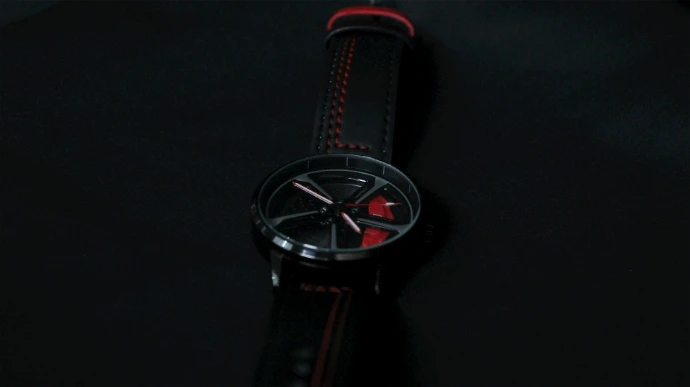 a watch sitting on top of a black surface